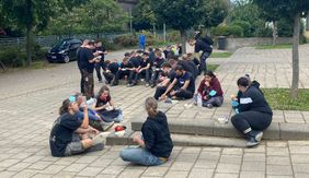 Eine von Martinas Hauptaufgaben ist es, Verpflegung für die Helfenden zu organisieren: Eine Gruppe junger Spontanhelferinnen und -helfer hat auf einem Parkplatz in Flerzheim Eintopf und etwas zu trinken erhalten