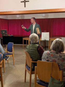 Zauberkünstler Jan Phillip Lehmker hält eine große Spielkarte hoch, mit der er einen Zaubertrick vorführte.