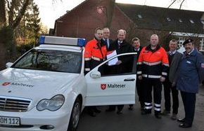 Mehrere Malteser Helfer stehen am Einsatzfahrzeug