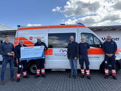 Bildunterschrift von links nach rechts: Stefan Weber, K&S - Werksleiter, Jan Fäller und Michael Aschenbrücker, Malteser, Daniel Völler, K&S – Betriebsrat, Felix Dittmayer, Kevin McGeeh vor dem Herzenswunsch-krankenwagen; Foto: Malteser Fulda.