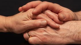 zwei Hände umschließen eine andere Hand