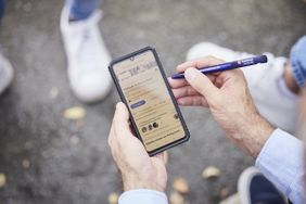 Ein Herr hält ein Smartphone in der Hand