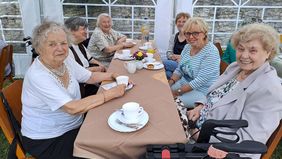 Seniorinnen sitzen an einem Kaffeetisch.