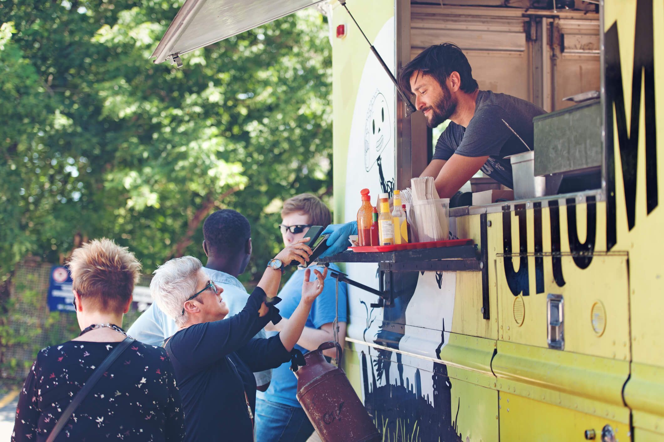 Mann bedient ältere Dame aus einem Foodtruck