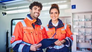 Rettungssanitäter und Rettungssanitäterin der Malteser in einem Rettungswagen prüfen die Ausrüstung