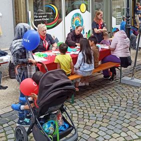 Kinder und erwachsene basteln an einem Tisch.