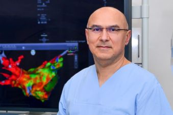 Stehender Mann in Funktionskleidung vor einem farbigen Monitor.
