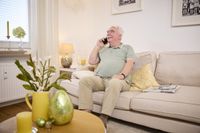 Ein Mann telefoniert auf einer Couch.