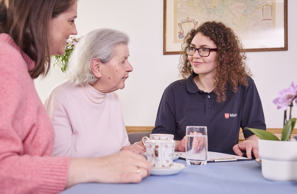 Demenzkoordinatorin der Malteser berät eine Dame mit demenzieller Erkrankung und eine zugehörige Frau.