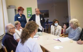 Am Tisch sitzen Patienten mit Königin Silvia. Foto: Lux/Malteser