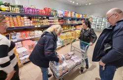 Vier Menschen, darunter Malteser, kaufen Lebensmittel ein