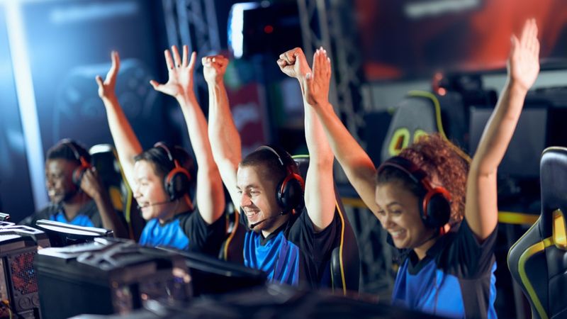 Ein E-Sport-Team jubelt vor ihren Bildschirmen.