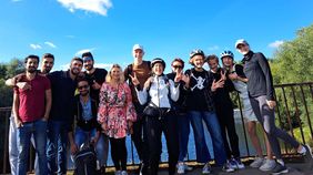 Menschen haben sich für eine Foto aufgestellt. Sie haben Fahrradhelme auf dem Kopf.