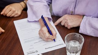 Malteser Patientenverfügung: Nahaufnahme einer Hand mit Stift in der Hand