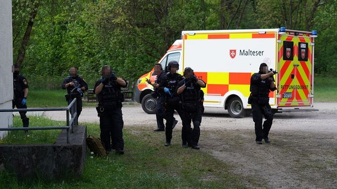 Mehrere Beamte üben das Sichern des Malteser Rettungswagens