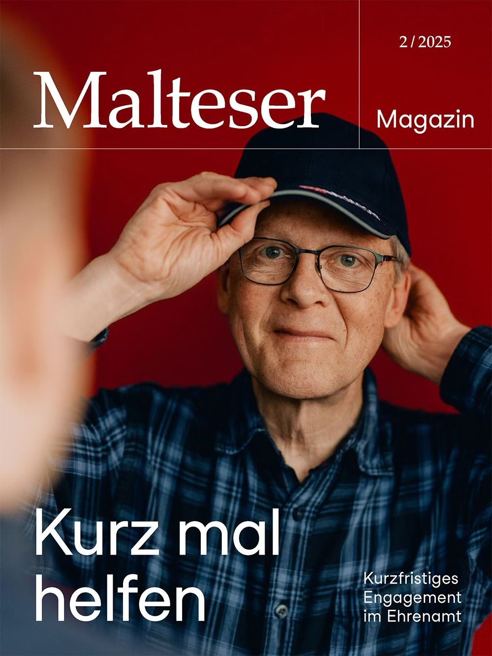 Malteser Magazin 02 in 2025 Mann in blaukariertem Hemd setzte sich Malteser Kappe auf