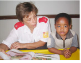 Care worker and child sitting at a table with books.
