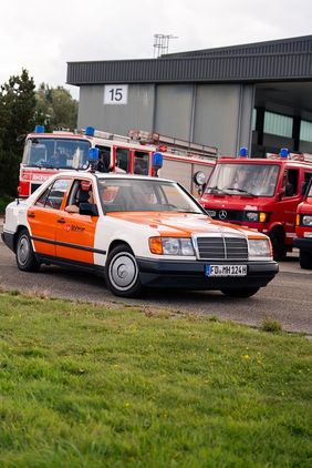 Ein Mercedes Oldtimer mit Blaulicht fährt über den Parkplatz