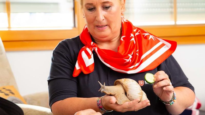 Eine Frau mit einer sehr großen Schnecke auf der 