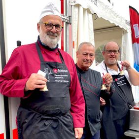 Drei Männer in Kochkleidung.