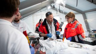 Bei einer Katstrophenschutzübung versorgen Malteser eine verletzte Person in einem Zelt.