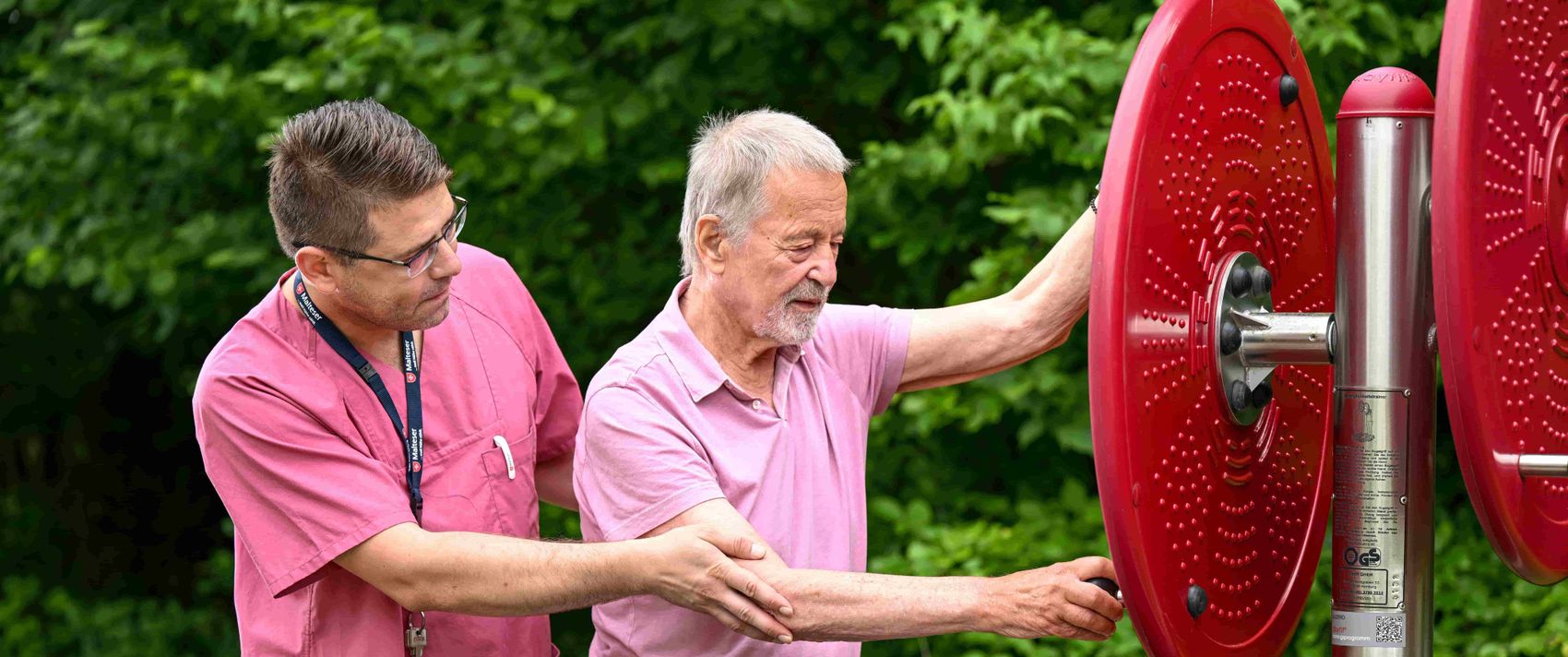 Ein Pfleger mit Patient bei einer Übung draußen