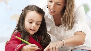 Eine Mitarbeiterin des Malteser Schulbegleitdienst hilft einem Mädchen beim Lernen.