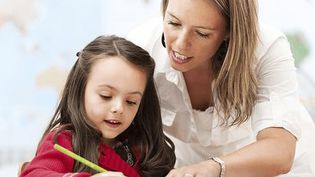 Eine Mitarbeiterin des Malteser Schulbegleitdienst hilft einem Mädchen beim Lernen.