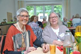 Zwei Frauen sitzen in einem Speisesaal an einem Tisch.