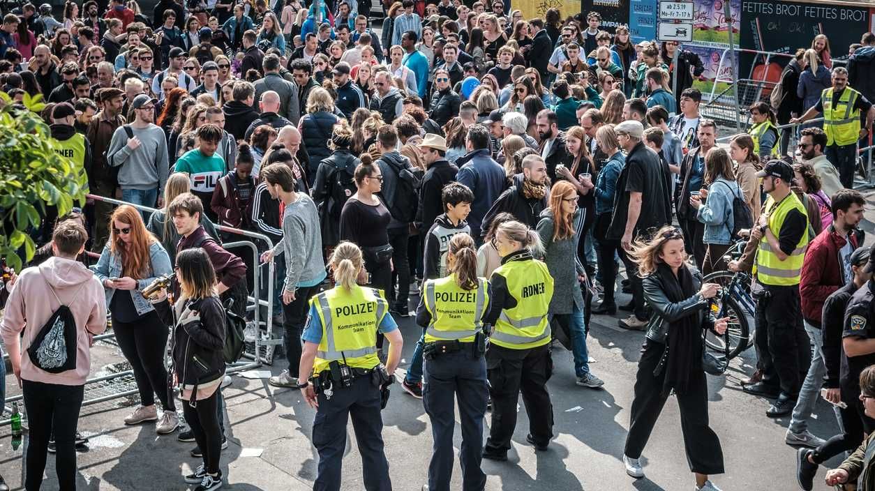 Eine Menschenmenge und Polizistinnen in gelben Warnwesten