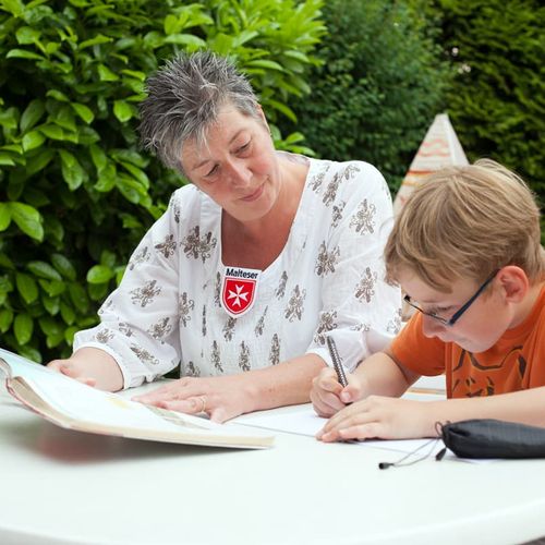 Frau betrachtet malendes Kind