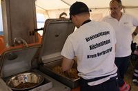 Ein Koch vom Küchenteam bereitet veganes Gyros zu. Ein anderer Malteser sieht dabei zu (Foto: Malteser Viernheim)