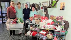 Eine Helferin der Malteser mit drei Mitarbeiterinnen des Altenheims Elisabeth in Rosenheim und vielen weihnachtlich verpackten Geschenken