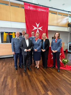 Von links nach rechts: Regionalleiter Rudolph Herzog von Croÿ, Präsident Georg Khevenhüller, em. Weihbischof Wilhelm Zimmermann, Andreas Blöink, Verena Hölken, Essener Bürgermeisterin Julia Jacob, Regionalgeschäftsführerin Dr. Sophie Gräfin von Preysing, Personen stehen als Gruppe vor einer Malteser Fahne im Hintergrund 