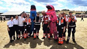 Das Einsatzteam mit drei Menschen, die ein Dino-Kostüm tragen.