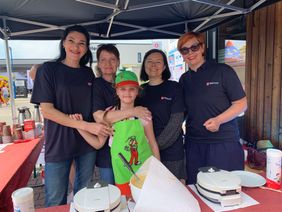 Geflüchtete Frauen und ein Mädchen unterstützen den Waffelstand der Malteser und backen für den guten Zweck. (Foto: Malteser Ludwigshafen)