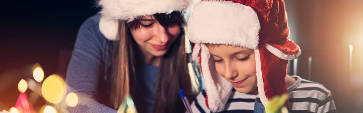 Junge Frau malt mit einem Kind Weihnachtsbilder