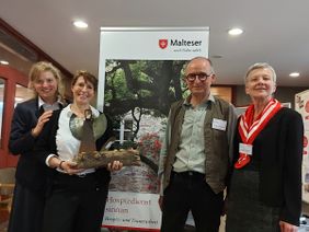 In der Ausstellung ‚Nic’s Thron‘ zeigt Michael Heinrichsdorff, Künstler und ehrenamtlicher Sterbe- und Trauerbegleiter besondere Momente der Hospizarbeit, festgehalten in Objekten und Worten. V.l.: Melanie Hofer, Sandra Winterling mit einem 'Engel', Michael Heinrichsdorff und Monika Schwertner.