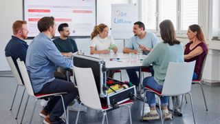 Sieben junge Erwachsene sitzen beim Malteser Erste-Hilfe-Kurs für Fortbildungszwecke zusammen.