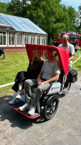 Zwei Personen sitzen als Gäste in der Rikscha