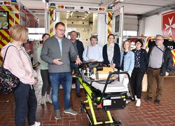 Ein Mann und eine Gruppe hinter einem Rettungswagen