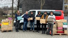 Mehrere Studierende mit zwei Vertretern der Malteser und vielen Hilfspaketten