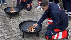 Ein Mann macht Feuer in einer Feuerschale