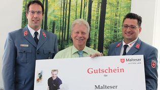 Gutschein Malteser Mahlzeitenpatenschaften wird überreicht.