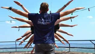 Kinder hintereinander mit ausgebreiteten Armen