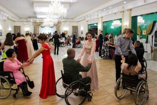 Menschen im Rollstuhl tanzen in einem Ballsaal