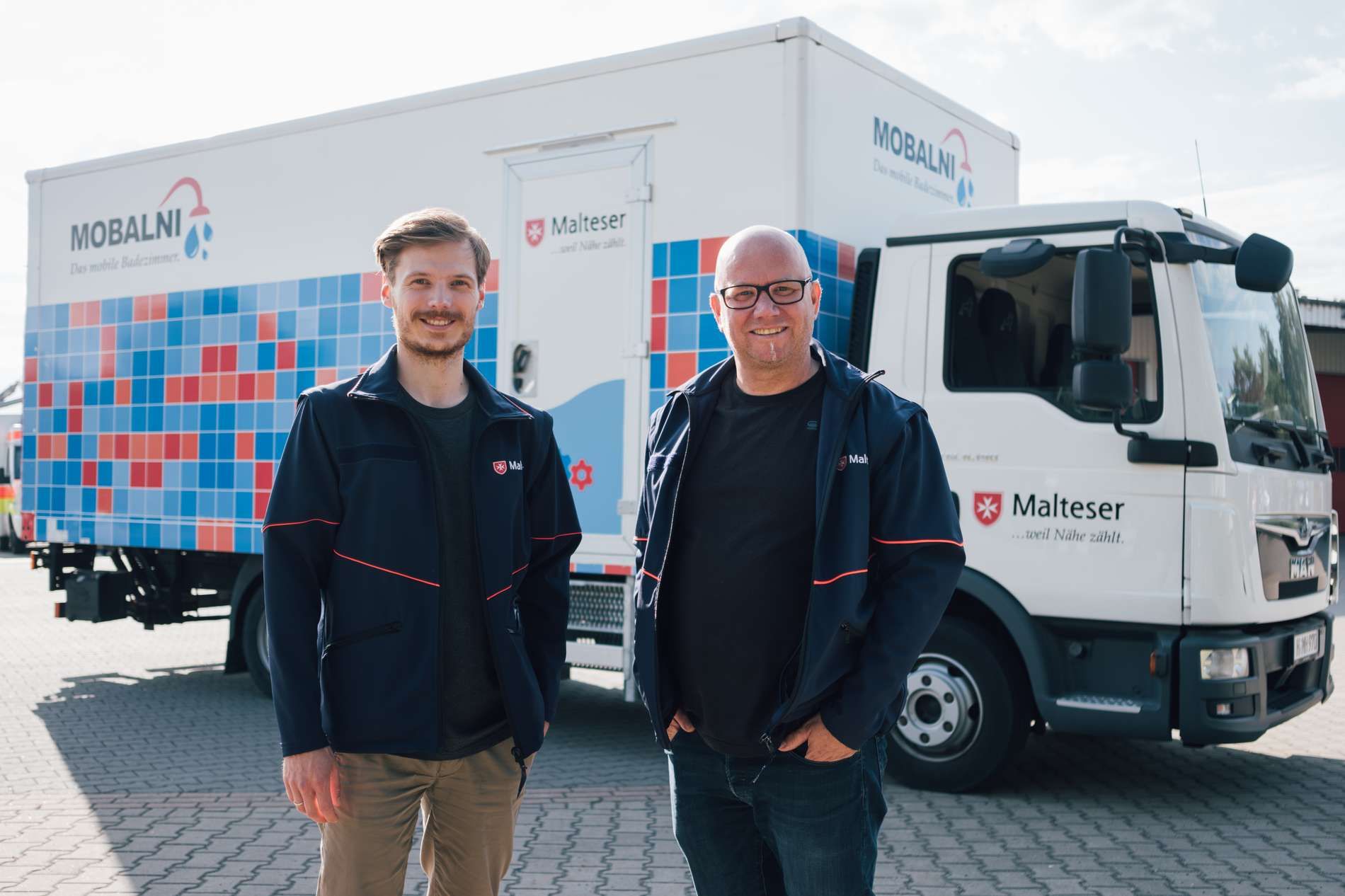 Projekkoordinator Julian Wundke und technischer Leiter Sven Pfeiffer vor dem Zugfahrzeug