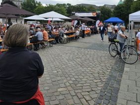 Eine Einsatzkraft der Malteser schaut auf den vollen Opernplatz in Hannover