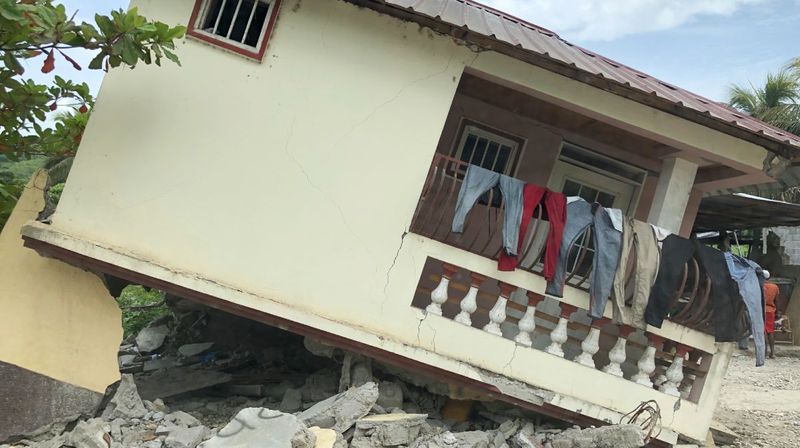 Ein schief stehendes Haus mit aufgehängter Wäsche in Haiti.