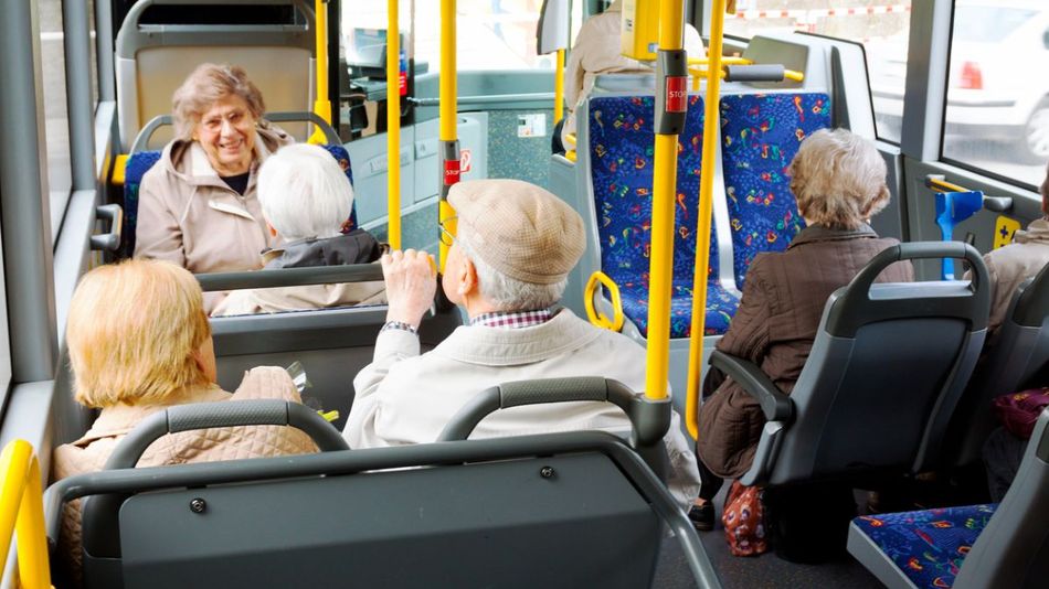 Eine Gruppe älterer Menschen in einem öffentlichen Bus.